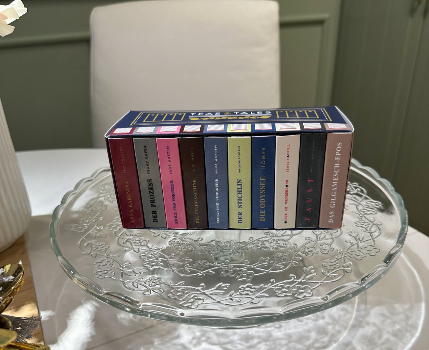 Die Teas & Tales Box mit zehn Mini-Buchklassikern, festlich angerichtet auf einer Glas-Etagere